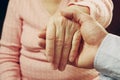 Mature female in elderly care facility gets help from hospital personnel nurse. Close up of aged wrinkled hands of senior woman. G Royalty Free Stock Photo