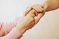 Mature female in elderly care facility gets help from hospital personnel nurse. Close up of aged wrinkled hands of senior woman. G Royalty Free Stock Photo