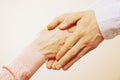 Mature female in elderly care facility gets help from hospital personnel nurse. Close up of aged wrinkled hands of senior woman. G Royalty Free Stock Photo