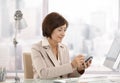 Mature female executive using smartphone in office Royalty Free Stock Photo