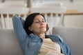 Mature female falling asleep on sofa at home