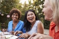 Mature Female Friends Enjoying Outdoor Meal In Backyard Royalty Free Stock Photo