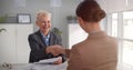 Mature female manager smiling and handshaking with european businesswoman after interview in office Royalty Free Stock Photo