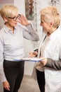 Mature female ophthalmologist writing patient`s data to a clipboard