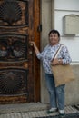 Mature female pilgrim knocking on door with shells symbolizing the Way of Santiago. Royalty Free Stock Photo