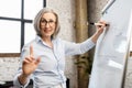 Mature female teacher writing on a whiteboard Royalty Free Stock Photo