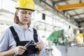 Mature female worker measuring metal with caliper in industry