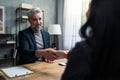 Mature financial advisor shaking hand with his client indoors in office. Royalty Free Stock Photo