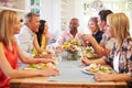 Mature Friends Sitting Around Table At Dinner Party