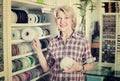 Mature glad woman customer picking various ribbon