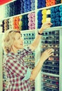 Mature glad woman customer picking various yarn