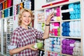 Mature glad woman customer picking various yarn