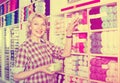 Mature glad woman customer picking various yarn