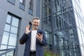 Mature gray-haired businessman talking video call, man using smartphone app to communicate with friends and colleagues Royalty Free Stock Photo