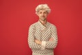 mature guy portrait. positive man in earflap hat. grizzled guy in sweater on red background. Royalty Free Stock Photo