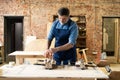 Mature handsome joiner work in carpentry. He is successful entrepreneur at his workplace. Royalty Free Stock Photo