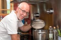 Mature handsome man cooking in home kitchen Royalty Free Stock Photo