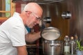 Mature handsome man cooking in home kitchen Royalty Free Stock Photo