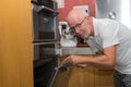 Mature handsome man cooking in home kitchen Royalty Free Stock Photo