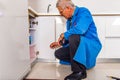 Mature handyman looking in the cupboard