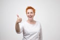 Mature happy cheerful woman with red hair showing thumb up. Royalty Free Stock Photo