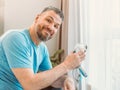 Mature happy man with chronic breathing issues considers using sitting on the bed in bedroom with CPAP machine. Royalty Free Stock Photo