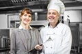 Mature head cook posing with female manager