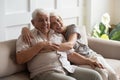 Happy mature couple resting on couch looking at camera Royalty Free Stock Photo