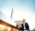 Hipster businessman with coffee standing on the bridge in London. Copy space. Royalty Free Stock Photo