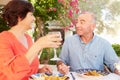 Mature Hispanic Couple Enjoying Outdoor Meal At Home Royalty Free Stock Photo