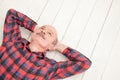 Mature hispanic man lie on white floor looking away thinking about future plans Royalty Free Stock Photo