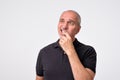 Mature hispanic man thinking with hands on chin looking away. Close up portrait of real people.