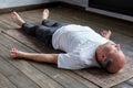 Mature hispanic man in yoga corpse pose in wooden floor. Royalty Free Stock Photo