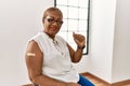 Mature hispanic woman getting vaccine showing arm with band aid very happy and excited doing winner gesture with arms raised, Royalty Free Stock Photo