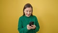 Mature hispanic woman with grey hair using smartphone smiling over isolated yellow background Royalty Free Stock Photo