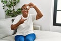 Mature hispanic woman sitting on the sofa at home smiling making frame with hands and fingers with happy face Royalty Free Stock Photo