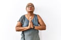 Mature hispanic woman wearing glasses standing over isolated background begging and praying with hands together with hope Royalty Free Stock Photo