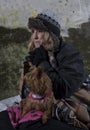 Mature homeless woman leaning against an old wall