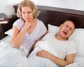 Mature irritated girl looking at snoring boyfriend Royalty Free Stock Photo