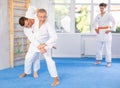 Mature judo fighters honing techniques during training bout in dojo