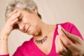 Mature lady with headache holding tablet or pill Royalty Free Stock Photo