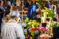 Mature lady looking at flowers at the weekly market