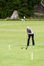 Mature lady playing croquet in a rural setting in Northumbria, England