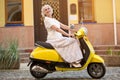 Mature lady rides a scooter. Royalty Free Stock Photo