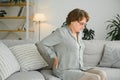 mature lady sitting on bed and touching her back, radiculitis and pain Royalty Free Stock Photo