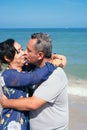 Mature latin couple kissing and walking on the beach Royalty Free Stock Photo