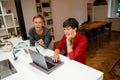 Mature lesbian couple using gadgets while sitting in kitchen