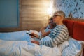 Mature love couple watching TV in bedroom Royalty Free Stock Photo