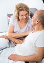 Mature loving couple lounging in bed after awaking cuddling