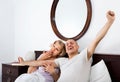 Mature loving couple lounging in bed after awaking cuddling